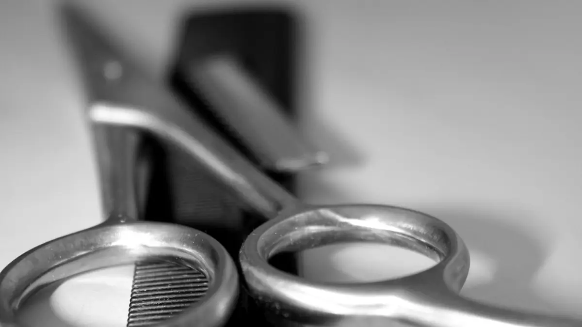 Silver hair-cutting shears on a reflective salon counter