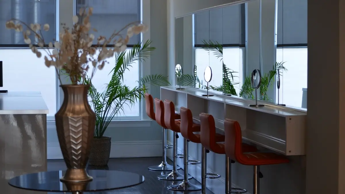 Modern hair salon interior with white styling chairs and illuminated mirrors