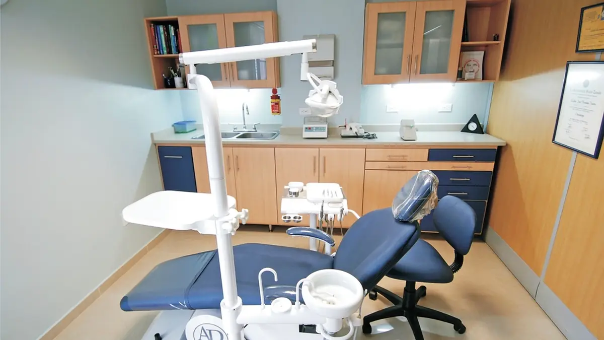 Modern dental treatment room with a patient chair and overhead light