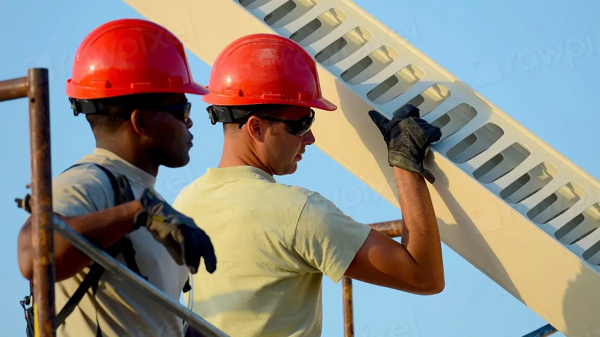 Technicians in hard hats working on a commercial building installation