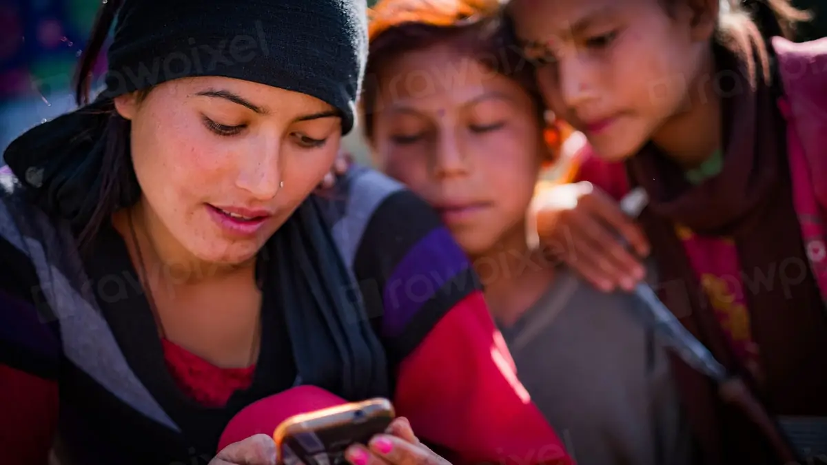 Group of women looking at a smartphone together outdoors