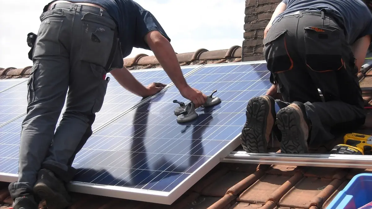 Workers installing solar panels on a residential rooftop